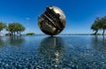 PESARO, ITALY - 21 AUGUST 2020: Grande Sphere by Arnaldo Pomodoro reflected in the water in Piazza della LibertÃÂ  in Pesaro
